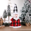 Santa Claus plush with red and black buffalo plaid hat and coat in a festive snowy scene - Santa Claus Style