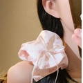 Pink floral satin scrunchie with bow detail worn as a stylish ponytail accessory - Crescent Pink Floral