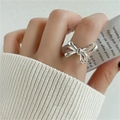 Close-up of 925 sterling silver bow ring on finger with white knit sleeve background - Bowknot Shape Silver Style(JZ0330)