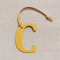 Close-up of yellow textured leather letter C charm with neat stitching and leather cord - Letter C Yellow