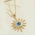 Detailed close-up of golden evil eye pendant with blue resin eye and sunburst eyelash charm - Sun Design 1