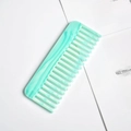 Detail of wide tooth acetate hair comb in mint green marble pattern on white desk - Jade Green Terrazzo