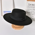 Detail of a vintage black wool felt boater hat with a wide brim and decorative ribbon bow - Adult / Black (Bow)