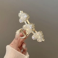 Gold claw clip with three rhinestone-encrusted hearts on a metal spring hair jaw - Three Hearts Rhinestone