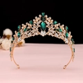 Close-up of golden Baroque crown featuring emerald gems and shimmering white rhinestones - KC Gold Green Crystal Crown