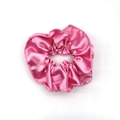 Detailed close-up showing the smooth pink satin texture and pleats of the elastic scrunchie - Pink