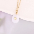 Macro view of gold chain with white stone teardrop pendant featuring a gold star inlay - White Oval Star (16#)