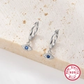 Close-up of S925 sterling silver earrings with blue zircon on beige stone surface - KE22287 Eyelash Eye Hoop / Silver