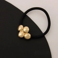 Minimalist elastic hair tie with four clustered gold-toned metallic spherical beads - Four Small Circles Gold