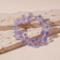 Dettaglio di perle di cristallo viola traslucide con riflessi cangianti e lucentezza - Ametista