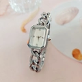 Reloj plateado rectangular para mujer con correa de cadena sobre un fondo rosa elegante - Plateado