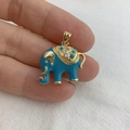 Golden elephant pendant with blue enamel and rhinestones shown in a hand close-up - Blue