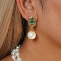 Close-up of vintage gold hollow earrings with green gemstone and white pearl droplet - Silver Needle Earrings - White