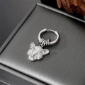 Macro view of silver panther head earring detail on a textured jewelry box background - Leopard Head