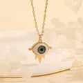 Macro shot of 18K gold evil eye necklace with green enamel and sparkling crystal accents - Green Eye-A4