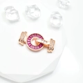 Roségoldener Schmuckverschluss mit lila Edelsteinen und Zirkonia auf weißem Podest - 15mm / Roségold