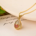 Close-up of 18K gold water drop necklace with red heart stone on elegant plate - Pink Heart Zircon/Gold Water Drop Pendant