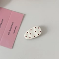 Dettaglio del fermaglio ovale color crema a pois rossi su un biglietto dallo stile minimal - Bianco Sporco
