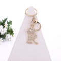 Golden metal keychain with crystal-studded letter R and crown on a display stand - Letter R / Gold