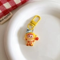Detailed view of a cute cartoon clown keychain charm with yellow D-ring on white ceramic tray - Clown