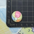 Macro shot of a 2.5cm colorful resin beach ball charm next to a measuring ruler - Colorful Beach Ball