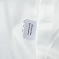 Macro shot of garment care label showing 92% Polyester and 8% Spandex fabric composition - XS / White
