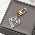 Detail of diamond-shaped iridescent acrylic keychain with a gold metal hook on grey box - Laser White Gem