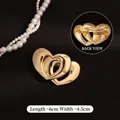 Detailed view of overlapping heart-shaped gold spring hair clip with smooth finish - Glossy Gold Double Heart Spring Clip