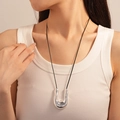Detail of a liquid metal U-shape pendant on a black cord necklace worn by a model - 15# Silver Metal U-Shape Sweater Necklace
