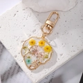 Face line art keychain with real dried flowers in gold resin frame on white stone - Yellow Three Flowers
