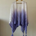 Detailed macro view of white to purple gradient knit shawl with delicate fringe tassels - Purple