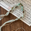 Gros plan du collier bohème avec ruban de soie verte, perles en pierre et touches de bois - Style Ruban Vert Clair Bois Turquoise