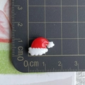 Detailed size view of a 1.5cm mini resin Christmas hat accessory on a measuring scale - 04-Wavy Christmas Hat