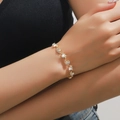 Nahaufnahme eines goldenen Wellenarmbands mit funkelnden Strasssteinen am Handgelenk - Armband / Gold