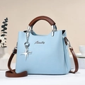 Borsa azzurra con trama litchi, manici marrone scuro e dettagli metallici argento - L25 P12 A20 / Celeste