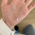 Elegant silver bead necklace featuring a teardrop-shaped clear pendant held in hand - Teardrop Transparent Pendant Bead Chain Necklace (XL3249)