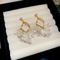 Detailansicht der goldenen Blumen-Ohrhänger mit weißen Muschelpetalen und Zirkonia - Gold