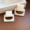 Detail view of retro geometric resin earrings with marble texture on a wooden surface - Creamy White Color-Block Geometric (10# Silver Earring Post)