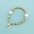Golden mobile phone chain with sparkling rhinestones and large pearls on blue background - Gold Pearl