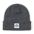 Berretto in maglia grigio scuro per neonati con simpatica toppa nera a forma di faccina - grigio scuro