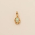 Single oval opal pendant with gold setting and sparkling diamond detail on neutral background - Oval October (Opal Zirconia)