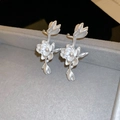 Detail view of silver lotus flower stud earrings on a gray velvet jewelry box display - Single Left Ear / Silver