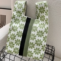 Close-up of white and green knitted tote bag with daisy patterns and black stripe detail - Green & Beige 8-Petal Flower