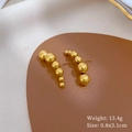 Detail view of gold beaded titanium earrings on leather mat with weight and size specs - Gold (Titanium Steel)