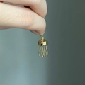 Detailed view of a golden jellyfish pendant with diamond accents and baroque pearls - Golden Jellyfish