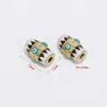 Detailed view of 16mm gold hex beads with enamel evil eye pattern and 3mm aperture - Evil Eye Barrel-3mm Hole