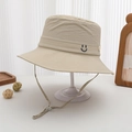 Detail of adjustable chin strap and smiley embroidery on cream polyester sun hat - 52-54cm (3-8 Years) / Beige