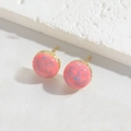 Detail of round gold earrings with pink and blue marbled resin finish on white stone - Pale Blue