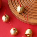 Gouden metalen bellen met rood koord en matte afwerking op houten dienblad voor DIY - Messing Bel Houten Kraal (Rood Touw)