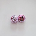 Detailed macro view of two pink metal bells with hanging loops and bottom slots - 2.0cm / Pink